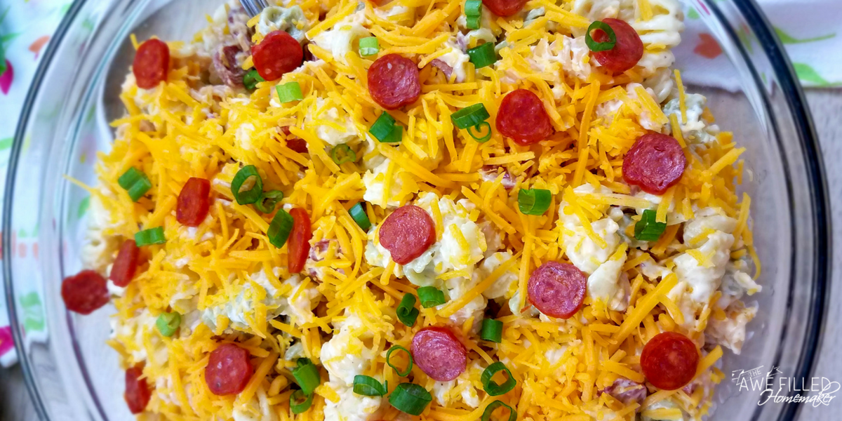 adding the cheese and pepperoni to the noodles 