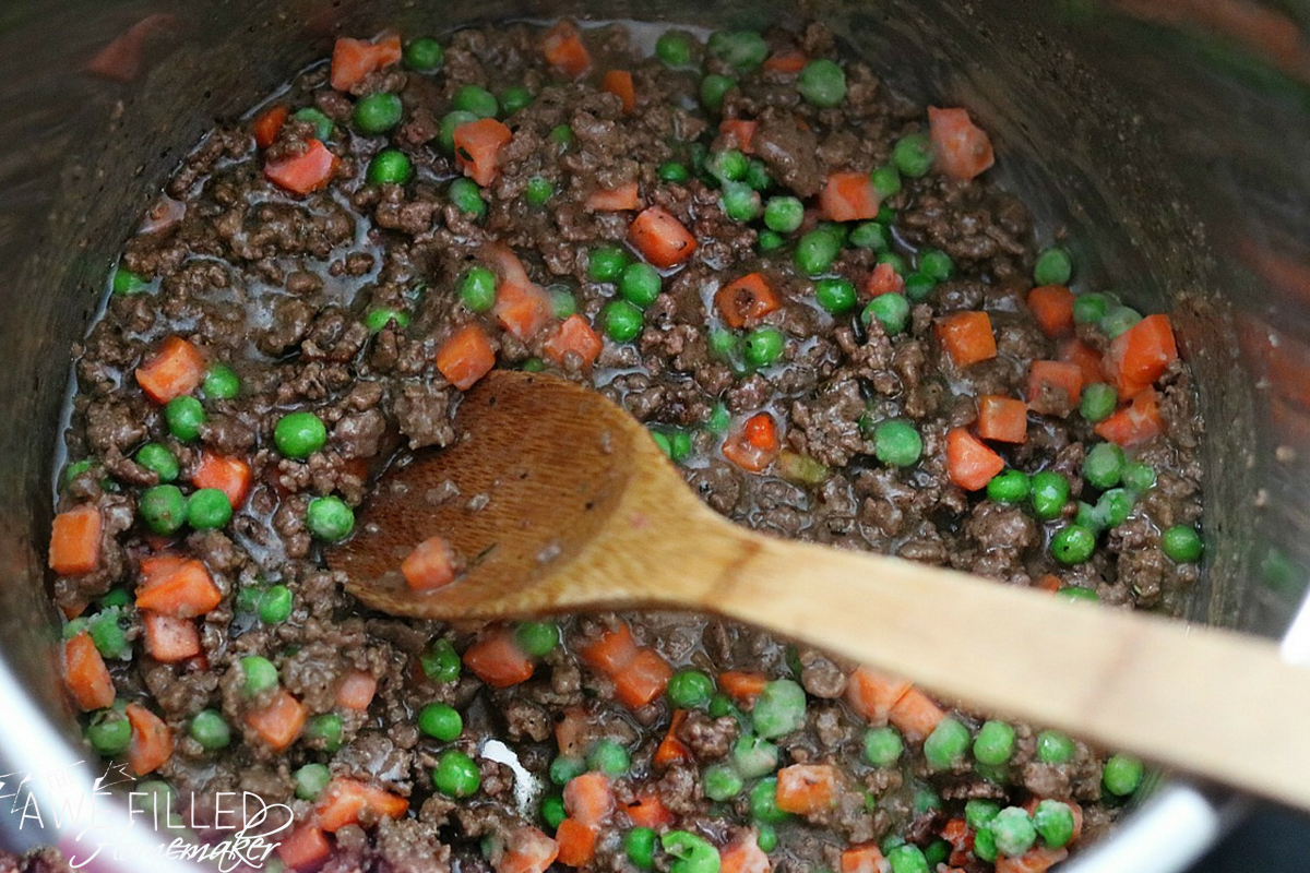 time to add vegetables including carrots and peas to ground beef in shepherds pie