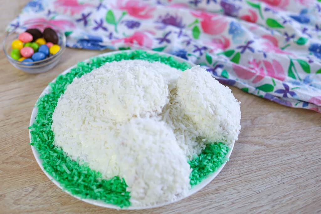 putting the green coconut shreds around the cake to look like grass 