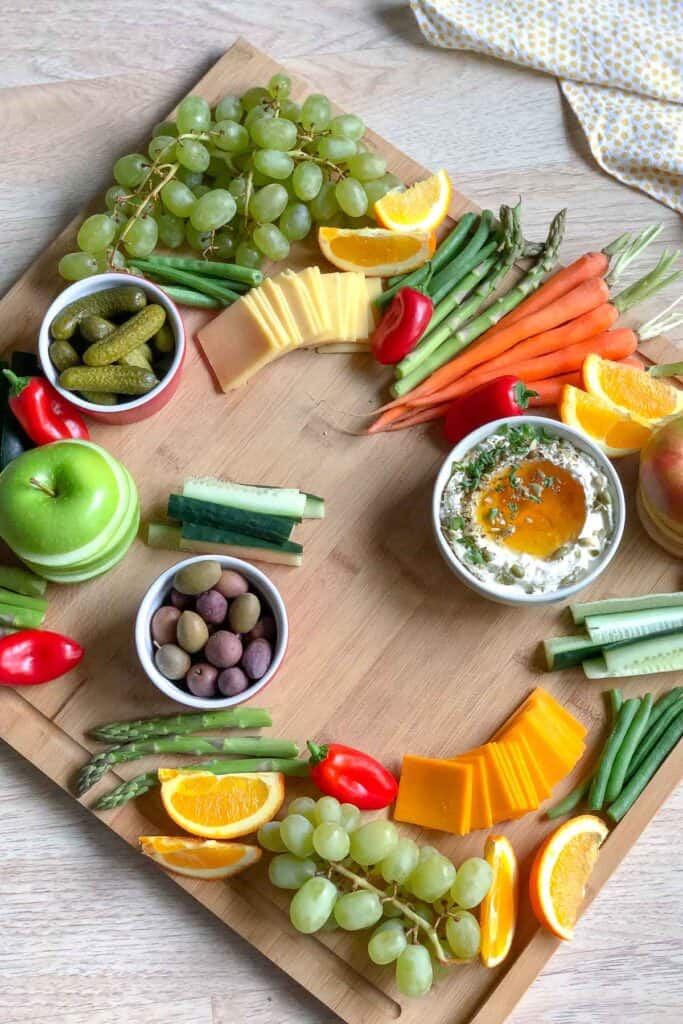 adding the ingredients to the charcuterie board
