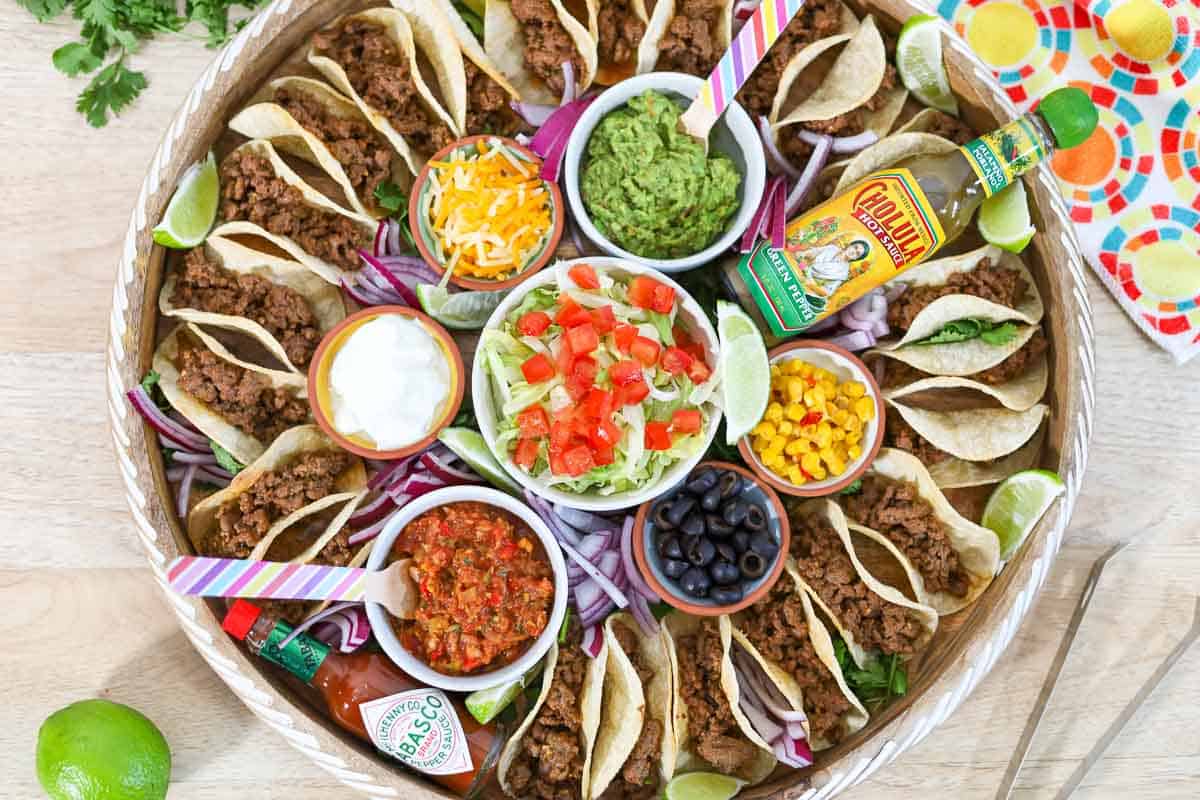 assembling the mini taco board with mini tacos and toppings